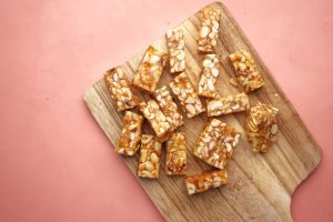 smithika peanut chikki 50rs mrp Wooden cutting board displaying tasty homemade nut bars, ready to eat.